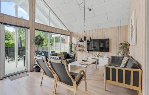 a living room with chairs and a table and a tv at 7 Bedroom Cozy Home In Sydals in Høruphav