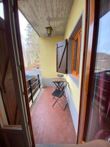 Zimmer mit einem Balkon mit einem Tisch und einem Fenster in der Unterkunft Chicca nel cuore dell'Abetone in Abetone