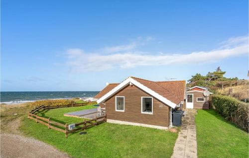 a house on the beach with the ocean in the background at Three-Bedroom Holiday Home In Slagelse in Slagelse