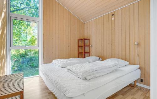 een wit bed in een kamer met een raam bij Amazing Home In Ebeltoft With Sauna in Øksenmølle
