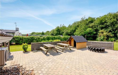 a patio with a picnic table and a shed at Hønsehuset in Skovby
