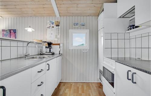 ロッケンにある3 Bedroom Beautiful Home In Lkkenの白いキャビネットとシンク付きのキッチン