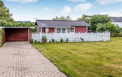 a red house with a white fence and a yard at Holiday Home Olymposvej in Slagelse