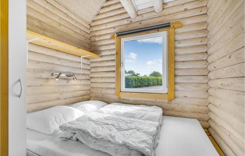 a bed in a wooden room with a window at Lovely Home In Tranekær in Tranekær