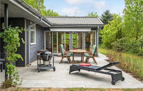 a patio with a grill and a table and chairs at Holiday Home Svinget Glesborg Iv in Fjellerup Strand