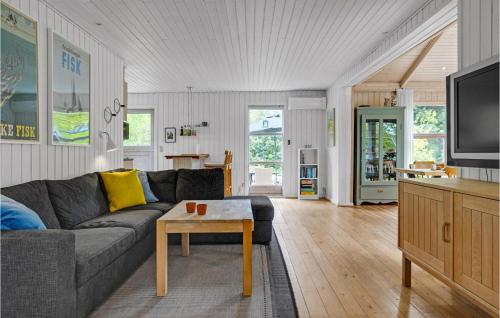 a living room with a couch and a table at Holiday Home Svinget Glesborg Iv in Fjellerup Strand