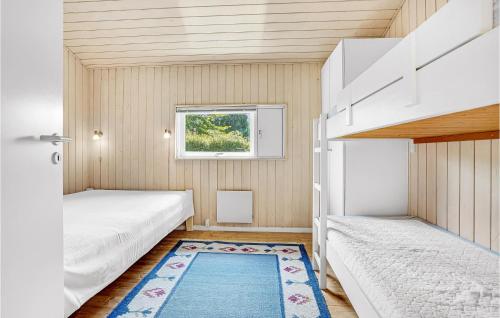 a small bedroom with two beds and a rug at Amazing Home In Bjert With House Sea View in Binderup Strand