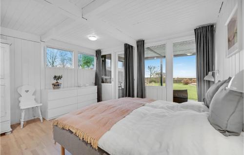a white bedroom with a large bed and windows at Beautiful Home In Odder With Outdoor Swimming Pool in Odder