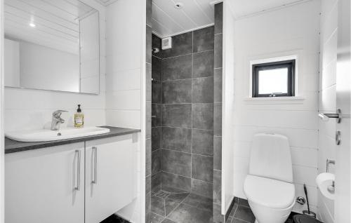 een witte badkamer met een toilet en een wastafel bij 4 Bedroom Cozy Home In Juelsminde in Juelsminde