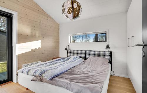 een bed in een slaapkamer met witte muren en een raam bij 4 Bedroom Cozy Home In Juelsminde in Juelsminde