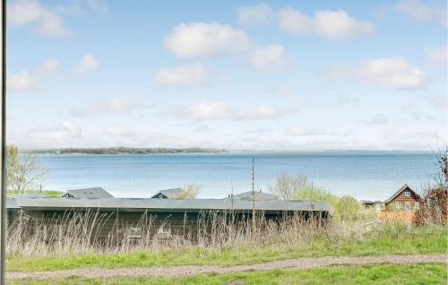 a train car sitting next to a body of water at Amazing Home In Sjølund in Sjølund