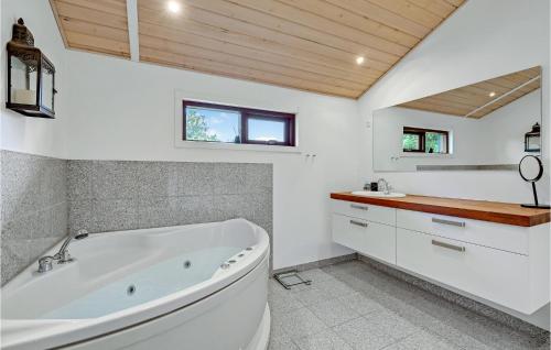 Ejstrup的住宿－3 Bedroom Awesome Home In Ejstrupholm，白色的浴室设有浴缸和水槽。