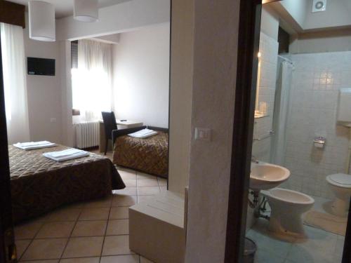 Habitación de hotel con 2 camas y baño en Hotel Eden en Vignola