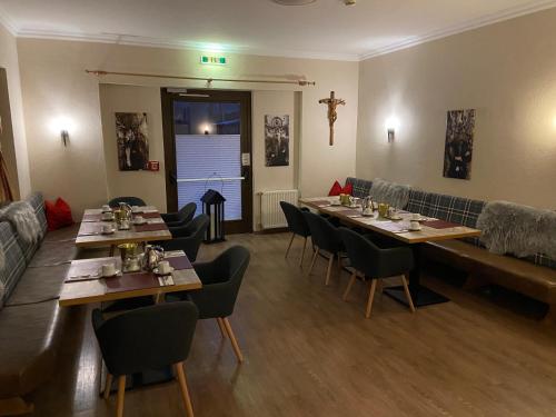 ein Restaurant mit Tischen und Stühlen in einem Zimmer in der Unterkunft Hotel Erika in Arzl im Pitztal