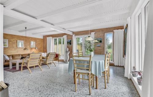 a dining room and living room with a table and chairs at Holiday Home Sønderskovvej in Illebølle
