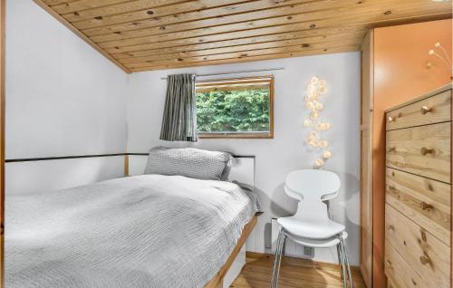 LokkebyにあるNice Home In Tranekr With 3 Bedrooms, Sauna And Wifiの小さなベッドルーム(ベッド1台、椅子付)
