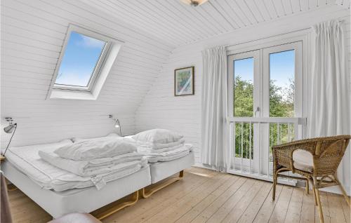 ein weißes Schlafzimmer mit einem Bett und einem Fenster in der Unterkunft 2 Bedroom Amazing Home In Rudkbing in Illebølle