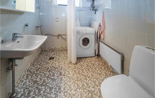 uma casa de banho com uma máquina de lavar roupa e um lavatório em Amazing Home In Askeby With Kitchen em Askeby