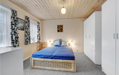 1 dormitorio con 1 cama con colcha azul en Cozy Home In Stubbekbing With Kitchen, en Stubbekøbing
