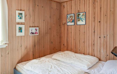 Pokój z łóżkiem w drewnianej ścianie z obrazami w obiekcie Stunning Home In lbk With Wifi w mieście Ålbæk