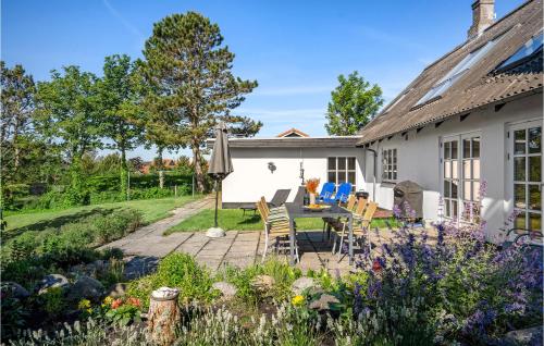 a patio with a table and chairs in a garden at 4 Bedroom Awesome Home In Glesborg in Glesborg