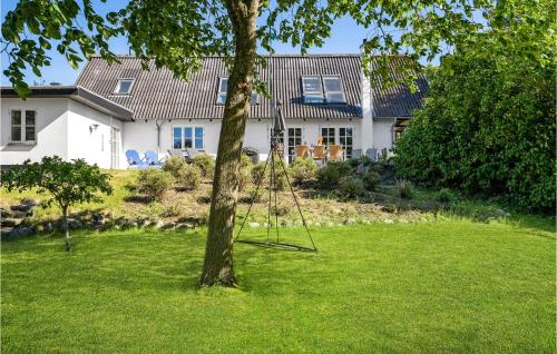 a swing hanging from a tree in front of a house at 4 Bedroom Awesome Home In Glesborg in Glesborg