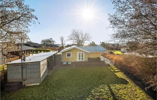 a small yellow house with the sun in the sky at Gorgeous Home In Bjert With Wifi in Binderup Strand