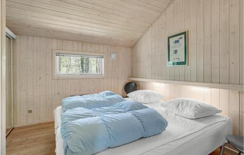 BedegårdにあるCozy Home In Nex With Saunaのベッドルーム1室(青いシーツと枕のベッド1台付)
