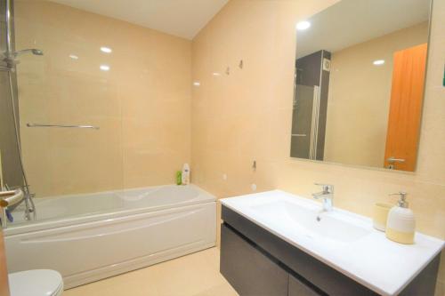 La salle de bains est pourvue d'un lavabo, d'une baignoire et de toilettes. dans l'établissement Casa da praia - by Smarthomes, à São Martinho do Porto