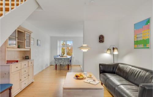 a living room with a leather couch and a table at Stunning Home In Rudkøbing With Kitchen in Rudkøbing