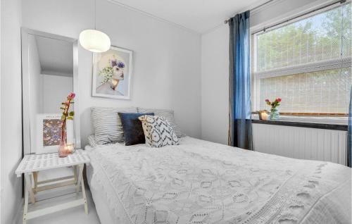 a white bedroom with a bed and a window at Beach Front Home In Slagelse With Kitchen in Lille Kongsmark