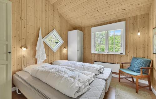 SpodsbjergにあるBeautiful Home In Rudkbing With Wifiのベッドルーム1室(ベッド1台、椅子、窓付)