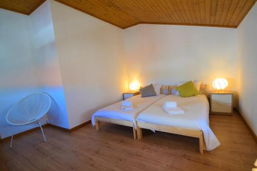ein Schlafzimmer mit einem Bett mit zwei Lampen und einem Stuhl in der Unterkunft Carmonas 32 Hill in São Martinho do Porto