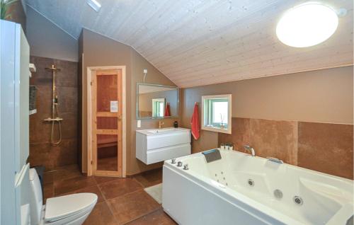 een badkamer met een bad, een toilet en een wastafel bij Gorgeous Home In Vggerlse With Sauna in Bøtø By