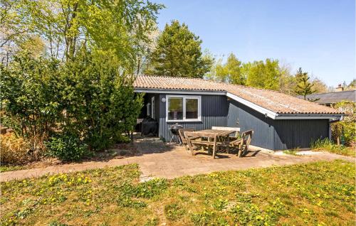 a small house with a picnic table and a patio at Three-Bedroom Holiday Home In Ronde in Rønde