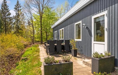 a group of chairs sitting on a patio next to a house at Three-Bedroom Holiday Home In Ronde in Rønde