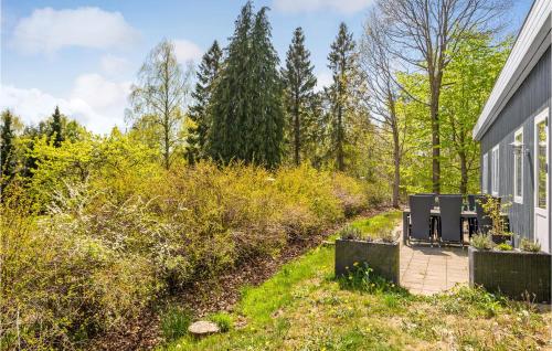 a garden with two chairs on a deck next to a house at Three-Bedroom Holiday Home In Ronde in Rønde