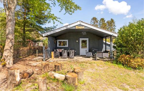 a black cottage with a patio and a table and chairs at Three-Bedroom Holiday Home In Ronde in Rønde