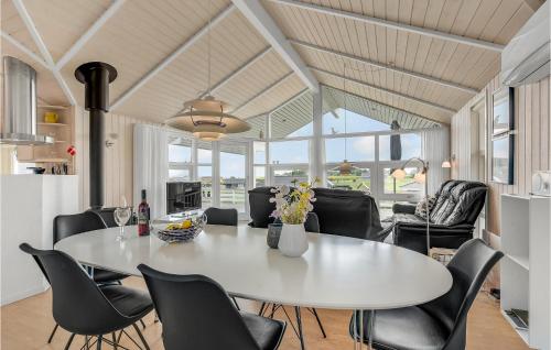 a dining room with a white table and black chairs at Three-Bedroom Holiday Home In Nordborg in Nordborg