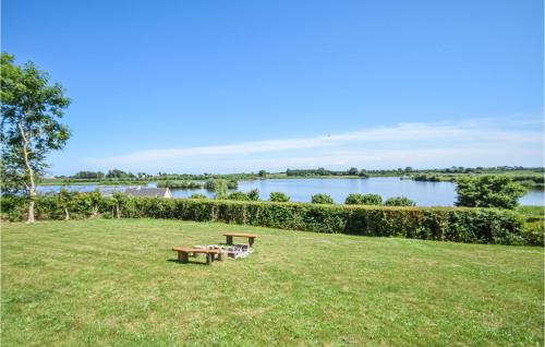 a picnic table in a field with a view of a lake at Holiday Home Botoften Tranekær In Dnmk in Botofte