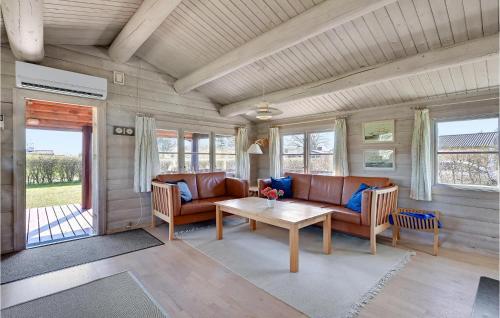 a living room with couches and a table and windows at Gorgeous Home In Rudkøbing With Wifi in Spodsbjerg