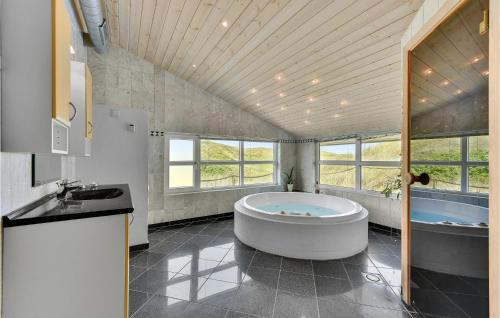 ヴィデ・サンデにあるAmazing Home In Hvide Sande With 4 Bedrooms, Sauna And Wifiの大きなバスルーム(大型バスタブ、シンク付)
