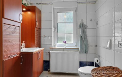 uma casa de banho com um WC, um lavatório e uma janela em Awesome Home In Rnne With Wifi em Rønne