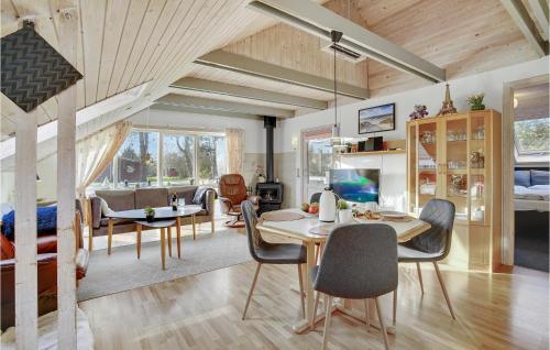 a kitchen and living room with a table and chairs at Three-Bedroom Holiday Home In Dannemare in Dannemare