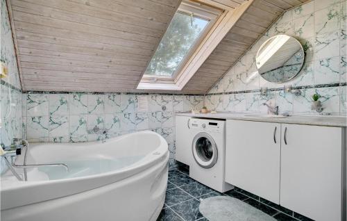 uma casa de banho com uma banheira e uma máquina de lavar roupa em Lovely Home In Dannemare With Kitchen em Dannemare