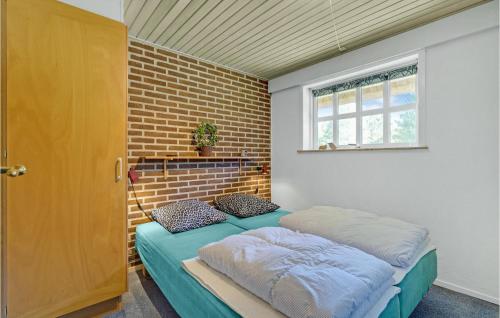 ブラーバンドにあるStunning Home In Blvand With 4 Bedrooms, Sauna And Wifiのレンガの壁のドミトリールームのベッド1台分です。