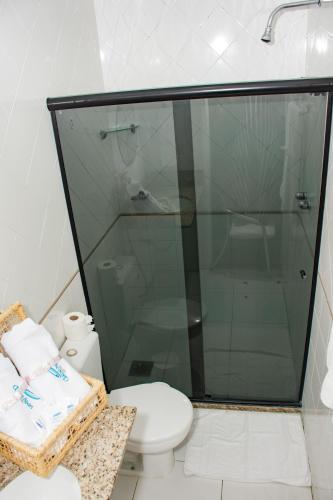 a bathroom with a toilet and a glass shower at Classe Apart Hotel in Feira de Santana