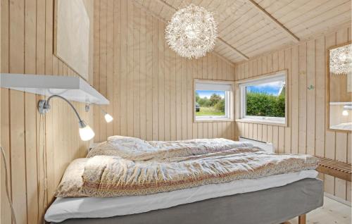 1 dormitorio con cama y lámpara de araña en Lovely Home In Allinge With Kitchen, en Allinge