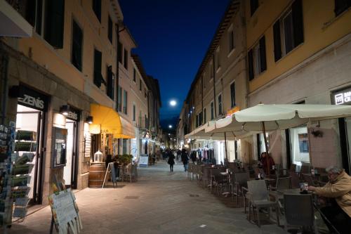 een lege straat met tafels, stoelen en parasols bij Residenza della Laguna in Orbetello