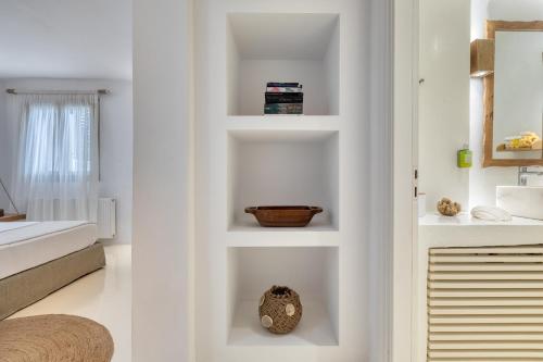 a room with white walls and white shelves at Amalgam Homes Paros in Ambelas
